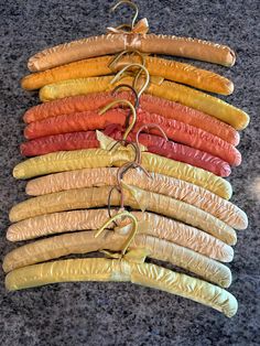 there are many different colored hotdogs on the counter together, and one is tied to a string