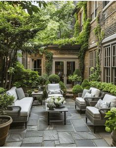 an outdoor living area with couches, tables and potted plants