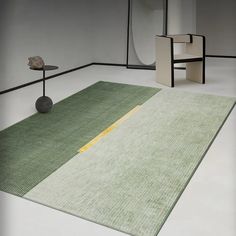 a room with a rug, chair and table on the floor in front of it