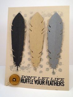 three different colored feathers on a card next to a button and some paper with the words don't let life ruffle your feathers