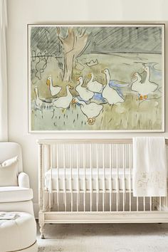 a baby's room with a white crib and large painting on the wall