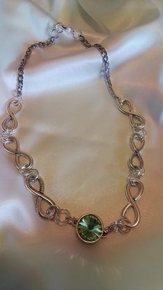 A Dazzling necklace made up of antique pewter links form an interesting design showcasing a peridot crystal at center to add some pizzaz. This infinity chain  of large links is lightweight and finished with a sturdy stainless silver chain...  The center is a peridot green crystal gem encased in a filigree design base.it measures 18 inches. Ready to send to you. And it ships free Silver Metal Chain Necklace As Gift, Silver Metal Chain Necklace For Gift, Silver Infinity Chain Jewelry, Sterling Silver Jewelry With Chunky Chain, Sterling Silver Jewelry With Chunky Chain In Silver, Infinity Metal Jewelry With Adjustable Chain, Infinity-shaped Metal Jewelry With Adjustable Chain, Infinity Shaped Metal Jewelry With Adjustable Chain, Metal Infinity Jewelry With Adjustable Chain