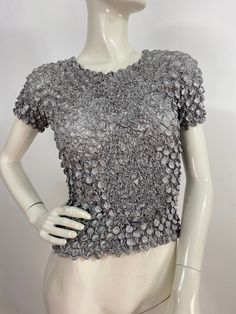 "Metallic silver top, vintage bubble top, 80s blouse, very stretchy size would fit from small-large, tiny top see measurements Measurements:  width stretches to 22\"  Mannequin measurements:  5'8\", bust 34\", waist 25\", hip 33\" Please note that vintage clothing sizes can vary greatly.  The Measurements provided  are approximate and are taken lying flat.  I suggest taking a similar garment from your wardrobe and measure it while lying flat.  This way you can compare measurements.  All of our p Silver Stretch Top For Spring, Silver Stretch Tops For Spring, Gray Fitted Blouse For Party, Gray Tops For Spring Evening, Gray Tops For Evening In Spring, Fitted Metallic Silver Tops For Evening, Glamorous Fitted Short Sleeve Tops, Metallic Silver Fitted Tops For Evening, Fitted Silver Tops For Spring