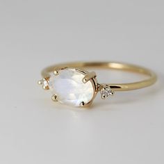 Luxury Oval Yellow Gold Moonstone Ring, 14k Gold Celestial Oval Rings, Elegant White Moon Shaped Opal Ring, Elegant White Moon-shaped Opal Ring, White Oval Cabochon Moonstone Ring In 14k Gold, 14k Gold White Moonstone Oval Cabochon Ring, White Moonstone Oval Cabochon Ring In 14k Gold, Celestial Oval Opal Rings, Fine Jewelry Oval Moonstone Ring With Rose Cut Diamonds