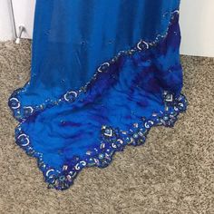 Indian Royal Blue Wedding Saree- Beautiful Royal Blue Color - Silk Material - Blouse Included - Contrast Color Beads And Stone Work On The Edges And All Over The Saree- Blouse Shoulder 14 Inches Armpit To Armpit 37 Waist 29 Inches Neck Deep To 5 Inches Saree Over All Length 6 Yards Belted To The Last End Is 29 Length From Waist To Toe 39.5 Inches Traditional Blue Gown With Traditional Drape, Traditional Blue Gown With Drape, Elegant Blue Embellished Lehenga, Fitted Blue Gown With Pallu, Elegant Royal Blue Saree Dress, Traditional Blue Embellished Dupatta, Blue Embellished Bollywood Dupatta, Blue Bollywood Style Embellished Dupatta, Traditional Blue Embellished Gown