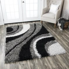 a black and white area rug on the floor in front of a door with a chair