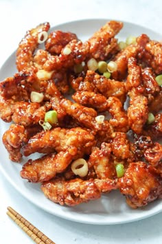 chicken wings with chopsticks on a white plate