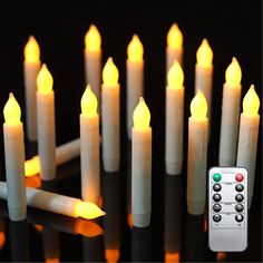 many lit candles with remote controls on black background