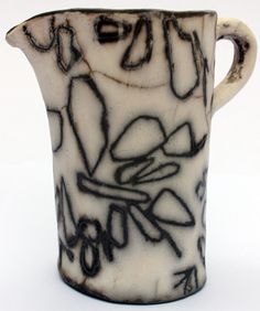 a black and white vase with graffiti on it's side, against a white background