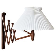 a table lamp with a white shade on it's base and wooden poles attached to the wall