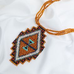 Trendy and tribal-inspired, the Mayan Pyramid Beaded Pendant Necklace makes a bold statement. Perfect for pairing with whites or denim for a great boho look. Made by women artisans of La Casa in Guatemala. Since 2000, La Casa Cotzal has designed a range of Guatemalan handcrafted pieces produced by artisan communities throughout the country. Mayan women traditionally have been backstrap loom weavers, but increasingly they are learning to use pedal looms as well. In traditional Guatemalan weaving, the two main specialized techniques are ikat and supplementary weft brocade. Artisans at La Casa are versed in both weaving techniques as well as in intricate bead work. The work provided by La Casa is vital to the women's families and communities. Glass beads & cotton thread Pendant: 3.25" H x 2" Bohemian Beaded Necklaces With Colorful Beads For Crafting, Artisan Beaded Jewelry For Festivals, Artisan Beaded Jewelry For Festival, Handmade Southwestern Beads For Jewelry Making, Southwestern Handwoven Beads For Festival, Handmade Bohemian Beaded Pendant Necklaces, Bohemian Handmade Beaded Pendant Necklaces, Bohemian Beaded Pendant Necklaces For Festivals, Bohemian Orange Beads For Jewelry Making