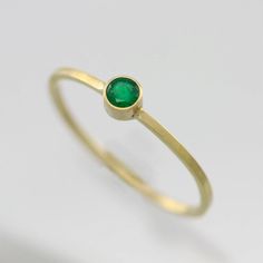 Handcrafted 14 carat yellow gold ring with a 3mm A grade faceted round Emerald stone in a bezel setting. Ring band measures 1mm wide and 1mm thick. Very dainty and elegant! Looks great stacked with other rings. Makes an excellent Mother's Ring! This item is made to order in your desired ring size, prices vary depending on requested size. Looks great paired with the necklace: https://www.etsy.com/listing/123058315/emerald-drop-necklace-in-14k-yellow-gold? Or the pendant: https://www.etsy.com/list Dainty Yellow Gold Emerald Ring, Dainty Yellow Gold Round Emerald Ring, Gold Emerald Ring With Round Band For Everyday, Gold Emerald Solitaire Ring With Round Band, Everyday Gold Emerald Ring With Round Band, Gold Solitaire Emerald Ring With Round Band, Everyday Yellow Gold Solitaire Emerald Ring, 14k Yellow Gold Stackable Rings With Bezel Setting, Gold Birthstone Ring With Smooth Bezel