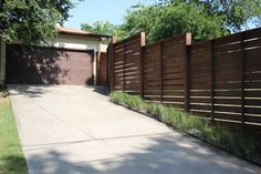 a driveway with a wooden fence next to it