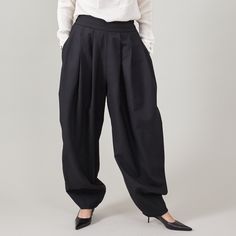 "Introducing our Pleated Balloon Pants for Women - a perfect blend of elegance, style, and ultimate coziness! Crafted from a black 100% wool fabric made in Italy, these pants are a testament to both luxury and comfort, making them a versatile one-of-a-kind addition to your wardrobe. The medium-thick wool fabric ensures their suitability for all seasons except summer, providing warmth without compromising style. Dressing up for special occasions or keeping it casual? These pants are the epitome of versatility. Pair them with an elegant top or a cropped lady blazer for a sophisticated look, or opt for a minimalist t-shirt and trainers for a more laid-back vibe. The elegant pleated wide waistband adds a lovely design detail for those who appreciate tucking their tops in. These Pleated Balloon Chic Baggy Harem Pants For Workwear, Tailored Black Cotton Pants, Black Wool Wide Leg Office Pants, Black Wool Dress Pants For Fall, Modern Black Ankle-length Pants, Black High-waisted Wool Wide Leg Pants, Black Wool High-waisted Wide Leg Pants, Black Wool Wide Leg Pants, Chic Black Wool Bottoms