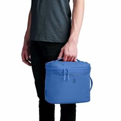 a man is holding a blue cooler bag