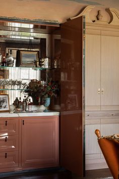 the kitchen is decorated in pink and white with lots of glassware on the shelves