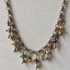 This Charm Necklace has Seven colorful Czech beads that are joined by ten of my treasure charms on a gorgeous hand made Silver Tribal Chain. This Artisan Necklace is whimsical and full of joy! A Boho Tribal Necklace, this beauty makes a bold statement. Treasure charms have beads, crystals, silver and pearls. Necklace measures 16 inches.  One of a kind! Charm Necklace, Silver Charm Necklace, Czech Glass Necklace, Artisan Necklace, Statement Necklace, Boho Necklace, Boho Jewelry Unique Metal Necklaces With Dangling Charms, Silver Charm Necklace With Dangling Charms, Unique Silver Charm Necklace With Dangling Charms, Unique Handmade Dangle Charm Necklaces, Handmade Spiritual Dangle Charm Necklaces, Handmade Spiritual Metal Charm Necklaces, Handmade Artisan Pendant Charm Necklaces, Unique Dangle Necklaces With Charms, Whimsical Handmade Dangle Necklaces