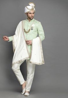 Art Silk Sherwani in Light GreenThis Readymade attire is Enhanced with Buttons and Resham Work. Crafted in Chinese Collar Neck and Full SleeveAvailable with an Art Silk Pant in Off WhiteDo note: Turban, Kanthimala, Dupatta, Brooch and Footwear shown in the image is for presentation purposes only. Half to one inch may vary in measurement. In case you want to purchase the Dupatta (WEBSITE ITEM CODE: MXX300). (Slight variation in actual color vs. image is possible) We sell all kinds of menswear. Me Embroidered Art Silk Bandhgala For Eid, Eid Embroidered Art Silk Bandhgala, Chanderi Bandhgala With Traditional Drape For Designer Wear, Green Chanderi Bandhgala With Traditional Drape, Art Silk Bandhgala With Chikankari Embroidery For Eid, Pista Green Chanderi Bandhgala For Eid, Eid Bandhgala With Chikankari Embroidery, Green Chanderi Sherwani With Traditional Drape, Designer Wear Churidar With Traditional Drape