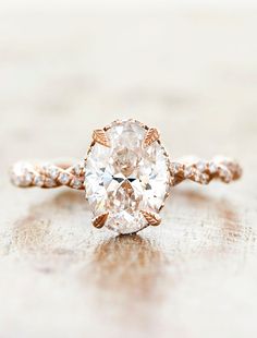 an oval cut diamond ring on a table