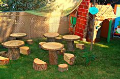 several pieces of wood sitting in the grass near a tree stump table and bench set