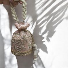 Indulge in timeless elegance with our exquisite bridal potli bag, meticulously crafted on blush pink velvet to capture the essence of luxury and tradition. Designed with South Indian brides in mind, this opulent accessory is adorned with intricate dabka, beadwork, sparkling stones, and shimmering sequins, ensuring a mesmerizing entrance on your special day. Elevate your bridal ensemble with this stunning potli bag, a symbol of sophistication and grace. Product Details: *Handmade with traditional Pakistani and Indian techniques *Spacious interior  *Measures 6 inches To explore additional styles, kindly visit our website at dulhansdiary.etsy.com. . . . . . . #silverpotlibag #handmadeclutch #bridalhandbag #weddingaccessories #ethnicbag #uniquegift #artisanmadeclutch #punjabiclutches #potlibag Formal Blush Bags With Detachable Handle, Formal Blush Shoulder Bag With Removable Pouch, Beige Handheld Wedding Bag, Elegant Blush Bag With Removable Pouch, Elegant Embroidered Bags For Ceremony, Feminine Gold Evening Bag For Wedding, Elegant Blush Shoulder Bag With Detachable Handle, Traditional Pink Shoulder Bag For Evening, Beige Handheld Evening Bag For Wedding