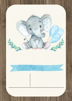 a card with an elephant on it and blue balloons in the middle, sitting on top of a wooden surface