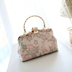 Add an original look to your outfit. These stunning purses are crafted with a focus on quality and detail. They’re especially suitable for weddings and special occasions. DESIGN – The fabrics are embossed with a floral design in pastel colours (Two styles). Enhanced with a gorgeous ornate clasp. FEATURES – Handle and chain shoulder strap. Size: 22 x 16 x 5 cm. MATERIAL – Polyester fabric, nylon liner.