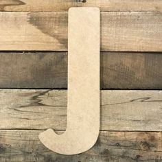 the letter j is made out of wood and sits on top of a wooden wall