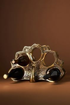 two glasses sitting on top of each other in front of a brown background with gold accents