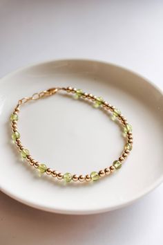 This charming August peridot bracelet will bring a cheerful pop of vibrant green to any outfit. Made with the August birthstone and a delicate gold filled beads, it's the perfect way to make a subtle statement. Peridot is said to promote good health and restful sleep. Made to last with 14k gold filled hardware. Comes in baby though adult sizes. Check out our size guide for help with sizing. We look forward to seeing you and your sweet little ones wearing your bracelets #joyfulbead. * Due to the Adjustable Lime Green Beaded Bracelets, Handmade Adjustable Lime Green Bracelets, Dainty Green Beaded Bracelets For Everyday, Adjustable Lime Green Bracelets As Gift, Dainty Green Bracelets With Round Beads, Dainty Green Round Bead Bracelets, Green Stretch Bracelet With Round Beads, Dainty Green Bracelet With Round Beads, Green Stretch Bracelet With Round Beads For Everyday