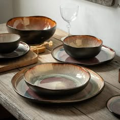 a wooden table topped with plates and bowls