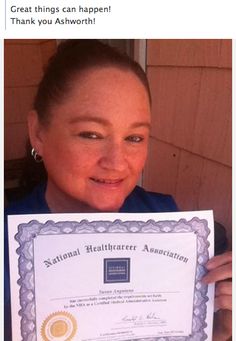 a woman holding up a certificate for an award