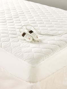 two white shoes sitting on top of a mattress