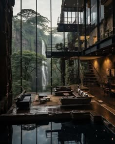 a living room filled with lots of furniture next to a waterfall in the middle of a forest