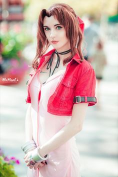 a woman dressed in pink poses for the camera