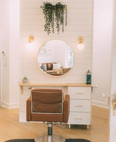 a chair sitting in front of a mirror on top of a wooden floor next to a table