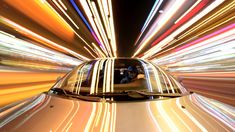 a car driving down the street at night with motion blurry lights in the background