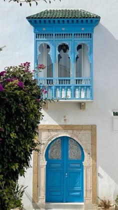 a blue door and window on a white building