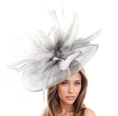 Hats By Cressida Kentucky Derby & Ascot Fascinator Hats Grey Metallic Silver Velidhoo Fascinator Hat Gorgeous long grey coque feathers on a layered metallic silver sinamay base.  Base measures about 12-14 inches wide Mounted with a matching headband. If you prefer a headband to match your hair, please make a note at check out what colour headband you want. Get ready to turn heads with the Velidhoo Fascinator Hat at your next fancy event! Perfect as a Kentucky Derby fascinator, Royal Ascot fascinator hat, or women's formal hat, this headpiece is all about elegance and sophistication. With long feathers, a sinamay base, and a unique design, you're sure to stand out from the crowd. Wear it to weddings, derby races, parties, church, or ladies day events and feel confident and stylish all day l Chic Wedding Mini Hat With Feathers, Elegant Silver Mini Hat For Summer, Chic Mini Hats With Feathers For Wedding, Elegant Feather Headpiece For Garden Party, Elegant Short Brim Fascinator With Feathers, Elegant Feathered Spring Headpieces, Wedding Hats With Feathers And Short Brim, Spring Wedding Hat With Feathers, Feathered Fascinator For Garden Party