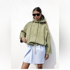 Jacket Made Of 100% Cotton Fabric. High Collar With Drawstring Hood. Long Sleeves. Button Tab Cuffs. Front Double Welt Pockets. Adjustable Drawstring Hem. Front Hidden Button Closure. Oversized Windbreaker For Spring Outdoor, Oversized Green Parka For Spring, Spring Khaki Cotton Parka, Oversized Green Spring Parka, Khaki Spring Windbreaker With Pockets, Green Parka For Spring Streetwear, Khaki Windbreaker With Pockets For Spring, Spring Khaki Windbreaker With Pockets, Oversized Khaki Parka For Spring