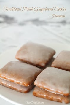 four glazed doughnuts on a plate with the words traditional polish gingerbread cookies