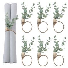 the napkin rings are tied with twine and decorated with small green plants on them