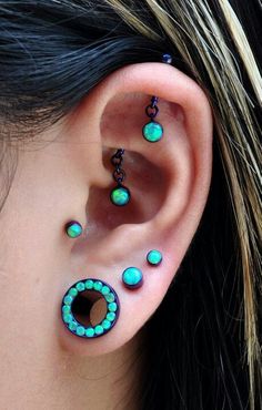 a woman wearing ear piercings with turquoise and green beads