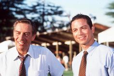 two men standing next to each other wearing ties