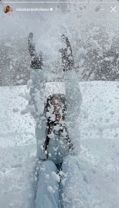 a person standing in the snow with their feet up and hands out to the side