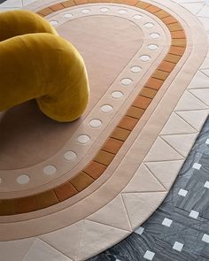 a yellow chair sitting on top of a floor next to a circular area with circles and dots