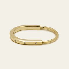 The Tiffany & Co Lock Bangle is all about bringing people together, and this bangle is a bold symbol of those personal connections that shape us. It's made for everyone, no matter your gender, and it has this cool clasp that's like a padlock, inspired by Tiffany's history. The bangle is crafted in 18k yellow gold and has sparkly diamonds for a touch of contrast. With a total carat weight of 0.31 and a medium size fitting wrists up to 6.25 inches, this Tiffany Lock Bangle is a simple, stylish way Stackable Open Ring Bracelets For Everyday, Modern 14k Gold Hoop Bracelets, Everyday Yellow Gold Open Ring Bracelets, Everyday Yellow Gold Open Ring Bracelet, Adjustable Open Ring Yellow Gold Bracelet, Modern Hoop Bangle For Everyday, Modern Hoop Bangle For Everyday Wear, Polished Bangle Bracelet For Promise Occasion, Modern Adjustable Hinged Bracelets