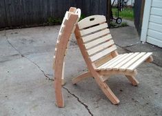 a wooden lawn chair sitting on top of a cement floor next to a garage door