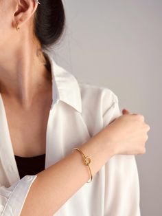 Elevate your wrist with our exquisite gold heart bangle, a symbol of timeless elegance and heartfelt sentiment. Crafted from lustrous gold-plated stainless steel, this bangle boasts durability and a luxurious shine that radiates sophistication.  The delicate heart charm adds a touch of romance, making it a perfect gift to express love and appreciation. Whether worn alone as a statement piece or stacked with other favorites, this bangle effortlessly transitions from day to night, enhancing any ensemble with its understated beauty.  Treat yourself or someone special to this versatile and enduring piece of jewelry, sure to become a cherished addition to any collection. Elegant Gold Heart-shaped Bangle, Elegant Bangle Charm Bracelet As Gift, Elegant Charm Bangle Bracelet Gift, Elegant Bangle Charm Bracelet For Gift, Elegant Charm Bracelet Bangle As Gift, Minimalist Heart Bangle Bracelet As Gift, Minimalist Bangle Jewelry For Valentine's Day, Elegant Heart Bangle Bracelet For Valentine's Day, Elegant Gold Bracelets For Valentine's Day