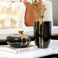 two vases sitting on top of a table next to each other with flowers in them